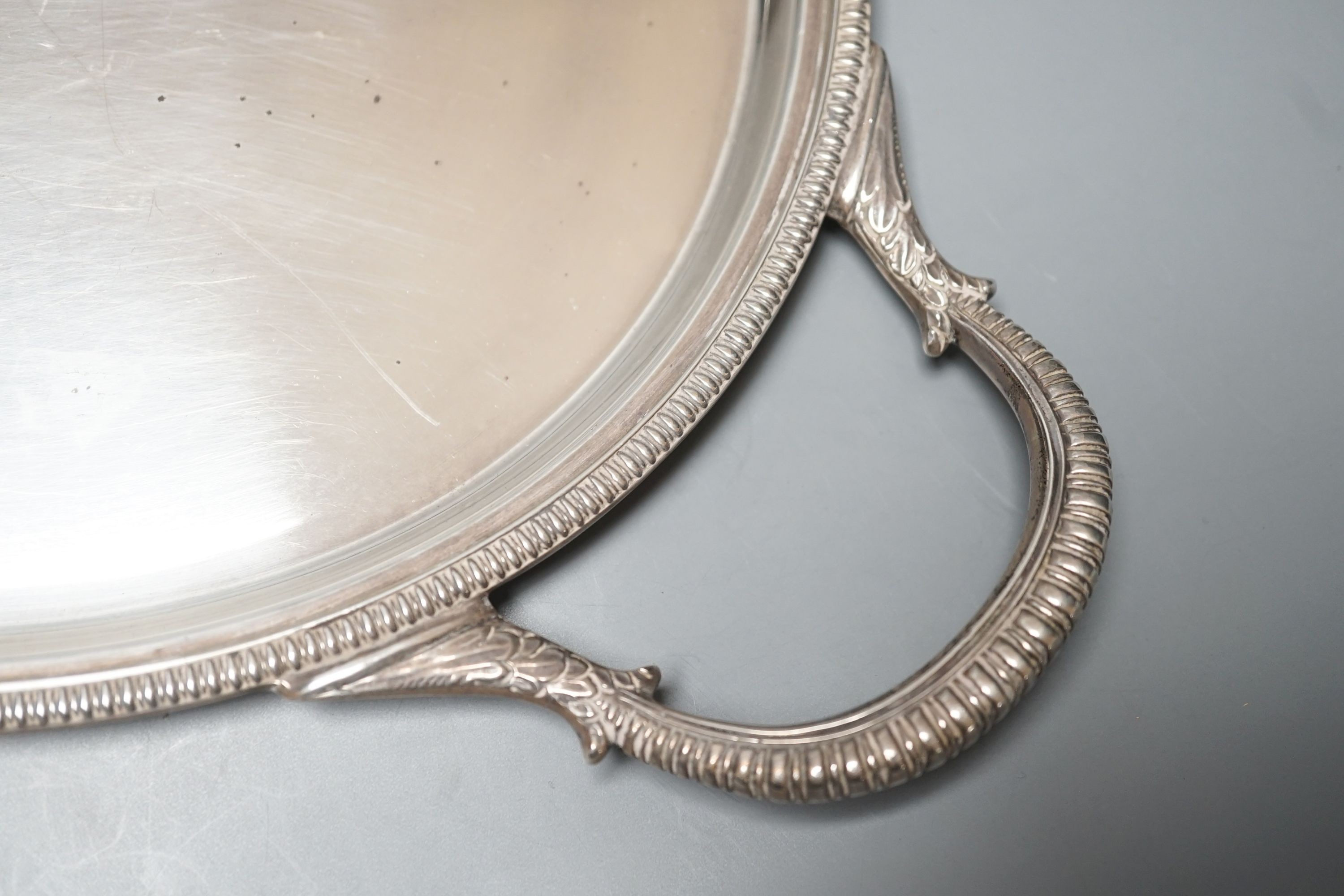 A mid 20th century silver two handled oval tea tray by Roberts & Belk, 56.3cm over handles, 57oz.